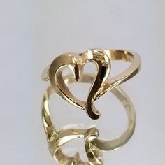 14k Gold Ring with a heart in the center. For only $289.00. Purchase comes with a gift box included. Ring size is adjustable, please note the size in the personalization section of checkout. Elegant Polished Heart Cut Ring, Heart Shaped Open Ring With Polished Finish For Wedding, Wedding Heart Ring With Polished Open Ring Finish, Wedding Heart Ring With Polished Open Design, Elegant Heart-shaped Ring With Polished Finish, Adjustable Gold Heart-shaped Initial Ring, Adjustable Gold Heart Initial Ring, Adjustable Yellow Gold Rings For Valentine's Day, Adjustable Heart Cut Yellow Gold Jewelry