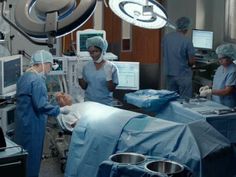 doctors and nurses in operating room with monitors