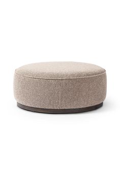 a round ottoman sitting on top of a white floor