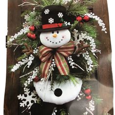 a snowman wreath on top of a wooden table