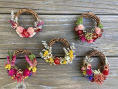 four wreaths with flowers are arranged on a wooden surface