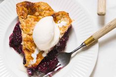 a piece of pie with ice cream on top is sitting on a plate next to a fork