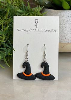 Witches Hat Polymer Clay Dangle Earrings, either Purple or Orange Accent Approximate Drop: 1.75 inches Witches Hat is approximately 1 inch x 1 inch Adjustable Nickel-free Earrings For Halloween, Adjustable French Hook Earrings As Gift, Adjustable Teardrop Hoop Earrings With French Hook, Unique Hypoallergenic Adjustable Earrings, Handmade Black Novelty Earrings, Themed Black Dangle Jewelry, Black Novelty Earrings For Gifts, Themed Black Dangle Earrings, Black Novelty Earrings For Gift