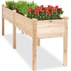 a wooden planter with red flowers in it