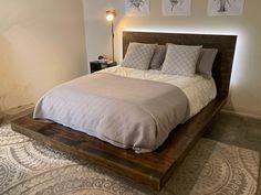 a bed sitting on top of a wooden platform next to a wall mounted light fixture