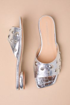 The Intentionally Blank Sadie Mercury Silver Leather Studded Slide Sandals are eye-catching and modern, which is the perfect combination for gathering compliments! Shiny, textured genuine leather shapes these stunning sandals that feature a single sole silhouette, a trendy square toe bed, and a wide toe strap embellished with mesmerizing silver studded details (of varying sizes). The sleek slide-on design will make these your go-to shoes for effortless styling! Available in Euro sizes only. 0. 7 Glamorous Leather Mules With Sculpted Heel, Elegant Flat Mules With Textured Footbed, Modern Silver Open Toe Mules, Modern Silver Mules For Summer, Formal Summer Mules With Textured Sole, Glamorous Leather Mules For Spring, Silver Leather Sandals With Sculpted Heel, Silver Open Toe Mules With Removable Insole, Chic Heels With Textured Footbed