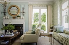 a living room filled with furniture and a fire place in front of a large window