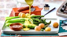 asparagus and other vegetables are being poured onto a plate