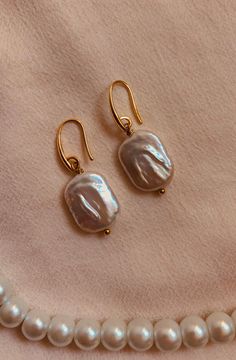 Discover the timeless elegance of these handcrafted gold earrings decorated with a genuine freshwater pearl pendant. Each piece has been crafted with the utmost care and attention to detail to offer you a unique piece of jewelry that enhances your beauty in a subtle yet remarkable way. The warm gold color of the earrings gives them a touch of luxury and sophistication, while the natural beauty of the freshwater pearls adds a touch of grace and delicacy. Each pearl is unique in its shape and colo Handmade Delicate Pearl Earrings, Delicate Gold Pearl Single Earring, Dainty Baroque Pearl Earrings Gift, Classic Pearl Pendant Earrings In 14k Gold Filled, Dainty Handmade Gold Pearl Earrings, Gold Pearl Earrings In 14k Gold Filled, Gold Pearl Pendant Earrings For Everyday, Everyday Gold Pearl Pendant Earrings, Everyday 14k Gold Filled Pearl Pendant Earrings