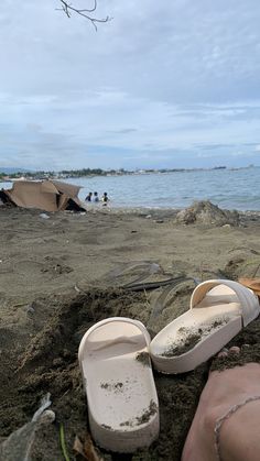 two pairs of slippers sitting in the sand