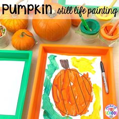 pumpkin still life painting for kids on a table with paper and paintbrushes next to it