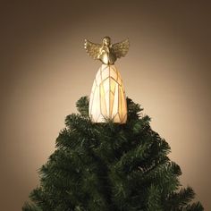 a christmas tree with an angel decoration on it's top and lights in the middle