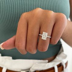 a woman wearing a diamond ring on her finger