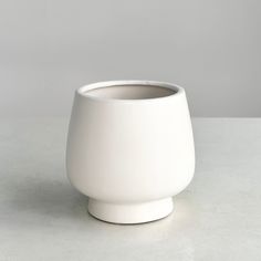 a white vase sitting on top of a table