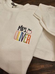 Personalized Teacher Embroidered Sweatshirt / Teacher name *The teacher's name will be in bright colors. If you would like it in one solid color, send me an email before you purchase.  Please review size chart before placing your order.  SHIPPING: Orders are shipped within 2 weeks. If you need the item sooner, message me.   CARE INSTRUCTIONS: Wash inside out and tumble dry on a low heat setting. Better results if you can wash on a cold cycle and hang/lay flat to dry. Hand Embroidered Teacher Shirt, Teacher Embroidered Shirt, Teacher Shirt Cricut, White Letter Embroidery Sweatshirt For School, School Crew Neck Embroidered T-shirt, School T-shirt With Embroidered Text And Crew Neck, School T-shirt With Embroidered Crew Neck, School Sweatshirt With Embroidered Logo, School T-shirt With Letter Embroidery