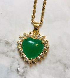 Green Jade Gold Out Lined Heart Pendant Green Heart-shaped Jewelry Gift For Her, Heart-shaped Emerald Necklace For Gift, Heart-shaped Emerald Necklaces As A Gift, Emerald Heart Gemstone Necklace, Emerald Heart Shaped Gemstone Necklace, Heart Shaped Emerald Necklace As A Gift, Heart-shaped Emerald Necklace As A Gift, Heart-shaped Emerald Gemstone Necklace, Spiritual Emerald Jewelry For Healing