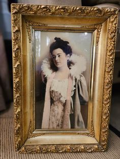 an old photo of a woman in a dress and fur stoler is on display