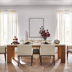 an elegant dining room with white walls and wood flooring, along with beige chairs