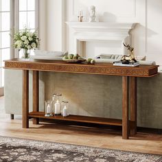 a console table with candles and flowers on it in front of a fireplace mantel