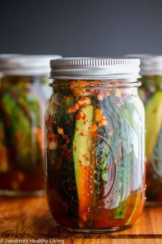 several jars filled with pickles and vegetables