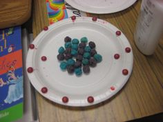 two paper plates with candy on them sitting on a table next to books and other items