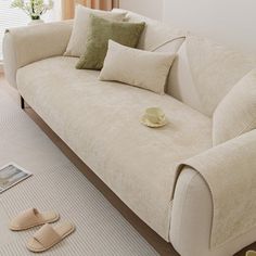 a couch with pillows and slippers on the floor