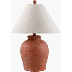 an orange ceramic lamp with a white shade on the base and a beige linen lampshade