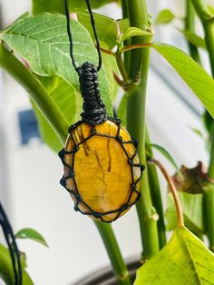 This handmade crystal necklace is featuring a drop shaped 2,5 cm wide and 3.5 cm high nellite amulet. The stone is fixed by the beautiful macrame technique in a thick, durable and resistant cotton cord. The necklace length  is adjustable. THE VIDEO IS TO SHOW THE WAY THE LENGTH CAN BE ADJUSTED ON THESE AMULETS. Nellite occurs when Tiger Eye and Pietersite meet and is thus a combination of both. The blue and golden minerals meet to form an extremely rare and unique appearance that glistens and shows it's true chatoyancy. Nellite is found in select mines in both South Africa and Namibia. Nellite awakens one's confidence and infuses your body with self-belief and appreciation for your accomplishments thus far. It is beautiful as a gift for both man and woman. Please note that the necklace is Handmade Amber Crystal Necklace For Meditation, Amber Crystal Pendant Necklace For Meditation, Amber Pendant Crystal Necklace For Meditation, Spiritual Oval Pendant Crystal Necklace With Gemstone, Spiritual Yellow Crystal Necklace Gift, Handmade Teardrop Crystal Necklace For Healing, Handmade Amber Teardrop Pendant Necklace, Handmade Amber Crystal Necklace Gift, Handmade Amber Crystal Necklace For Gift