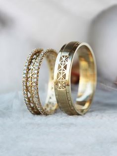 two gold wedding bands with diamonds on them