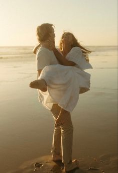 two women are standing on the beach with their arms around each other as they hug