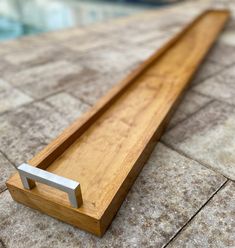 a wooden bench sitting on top of a tiled floor