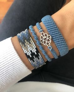 a close up of a person wearing two bracelets on their wrist and one with a flower