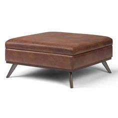 a brown ottoman sitting on top of a wooden table