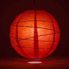 a red paper lantern is lit up in the dark