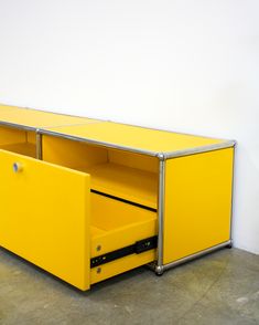 a yellow cabinet sitting on top of a cement floor