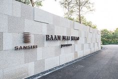 the entrance to an office building with signage on it's wall and trees in the background