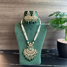 22k gold plated Green Enamel meena work Pearl Long Tayani Necklace set. Experience elegance and tradition with our 22k gold plated Green Enamel meena work Pearl Long Tayani Necklace set. The intricate meena work adds a touch of luxury, while the long tayani design exudes sophistication. Elevate any outfit with the timeless beauty of pearl and gold. Gold Plated Meenakari Jewelry For Puja, 22k Gold Meenakari Chandbali Jewelry Sets, Gold Plated Meenakari Temple Necklace In Chandbali Shape, Gold Plated Meenakari Temple Necklace Chandbali, Gold Plated Meenakari Temple Necklace In Chandbali Style, Yellow Gold Kundan Necklace With Meenakari For Puja, Gold Plated Kundan Necklace With Tilla For Diwali, Traditional 22k Gold Kundan Necklace With Zari Work, Ceremonial Kundan Jewelry Set With Meenakari