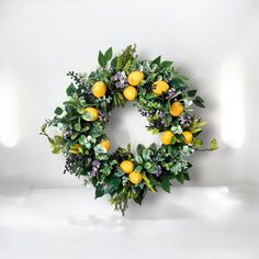 a wreath with lemons and greenery is displayed on a white surface in an empty room