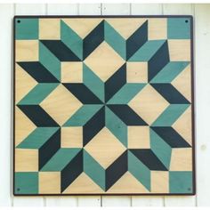 a wooden wall hanging with an abstract design on it's side and the bottom half painted teal