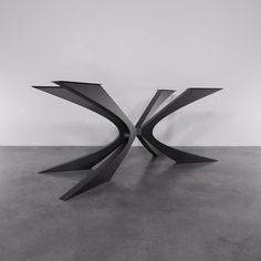 a black and white photo of a table with curves on the top, in an empty room