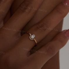 a woman's hand with a diamond ring on top of her finger and the other hand holding it