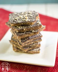 a stack of brownies sitting on top of a white plate covered in powdered sugar