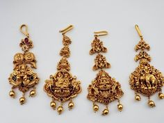 three pieces of gold jewelry on a white surface