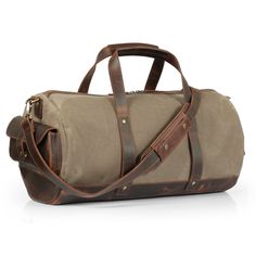 the duffel bag is made from canvas and has brown leather trims on it