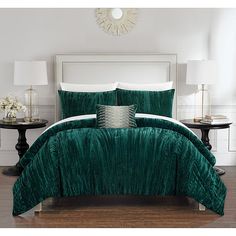 a bed with green comforter and pillows in a room