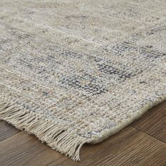 an area rug with wooden flooring on top of it and a wood floor in the background