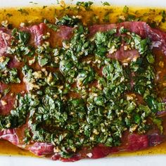 raw meat with herbs and seasoning on top