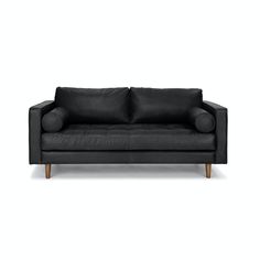 a black leather couch with wooden legs