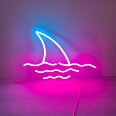 a neon sign with a sailboat on it's side in the middle of a room