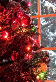 a decorated christmas tree in front of a window